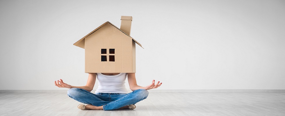 Girl in lotus pose with cardboard house on head