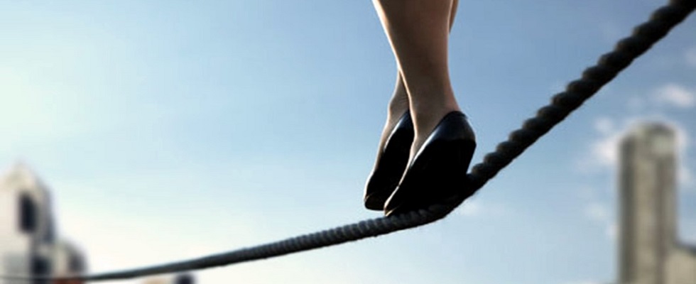 Woman walking on tightrope over cityscape, low section